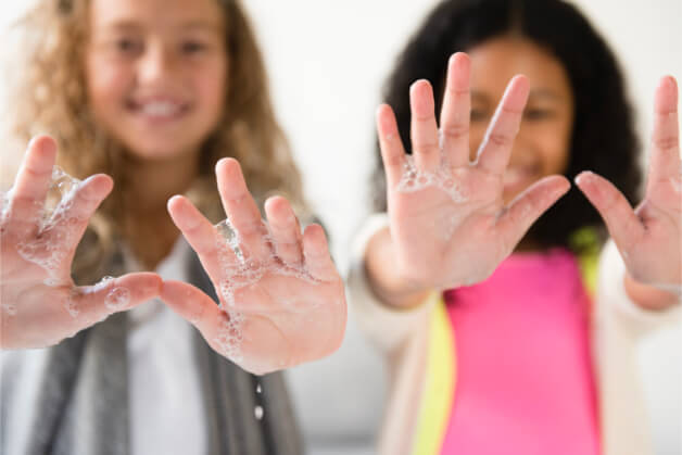 Niños participando en un juego de higiene de manos, aprendiendo de forma divertida la importancia del lavado correcto. Niños participando en un juego de higiene de manos, aprendiendo de forma divertida la importancia del lavado correcto.